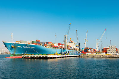 Commercial dock by sea against blue sky