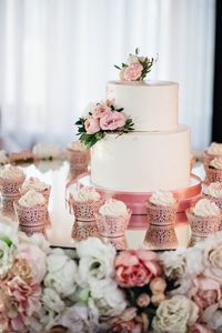 Close-up of flowers by wedding cake on table