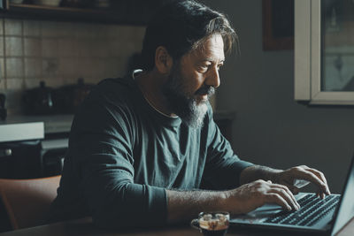 Young man using laptop at table