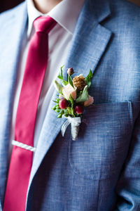 Midsection of man with flowers in blazer