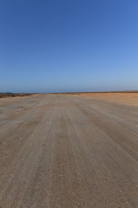 Scenic view of desert against clear blue sky