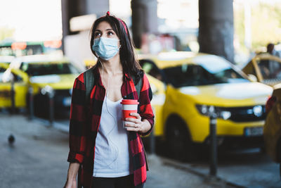 Young woman standing on street in city