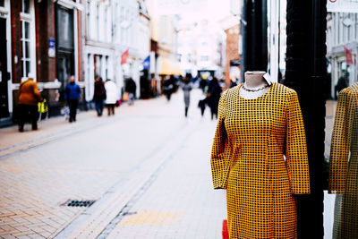 Front view dress with silhouette of people walking on street in city