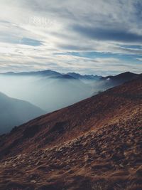 Scenic view of mountains against cloudy sky