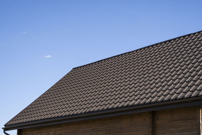 Low angle view of building roof against clear sky