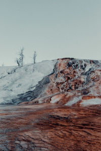 Scenic view of land against clear sky during winter