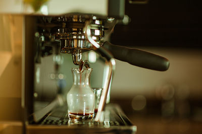 Close-up of coffee pouring in jug at cafe