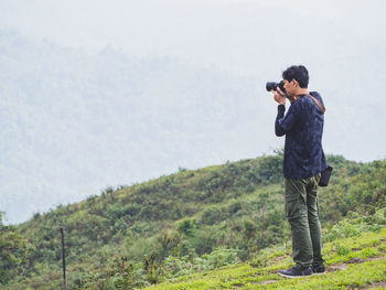 Side view of man standing on mountain