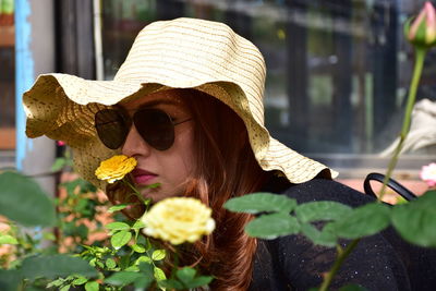 Close-up of woman smelling flower in park