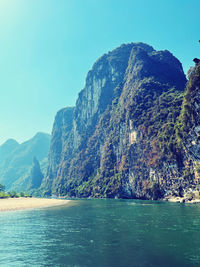 Scenic view of sea and mountains against clear sky