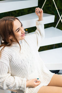 Portrait of young woman sitting on table