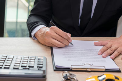 Midsection of man using mobile phone on table