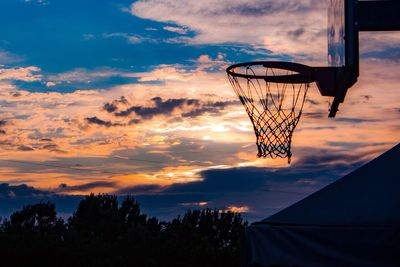 Silhouette basketball hoop against cloudy sky during sunset