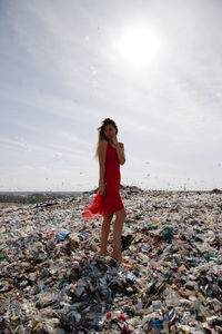 Full length of young woman standing on garbage