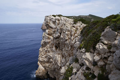 Rock formations by sea against sky