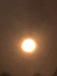 Low angle view of illuminated sun against sky