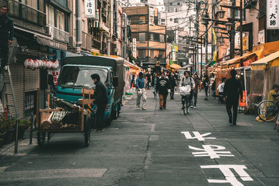 Group of people on road against buildings