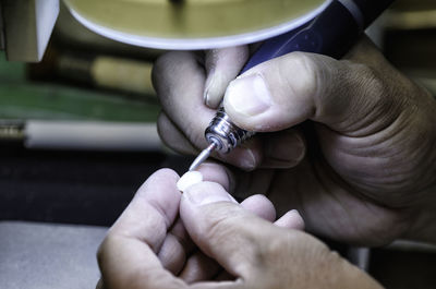 Cropped hands of person cleaning dentures in clinic