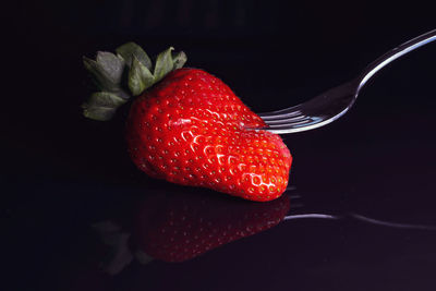 Close-up of strawberry over black background