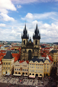 View of buildings in city against cloudy sky