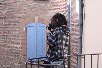 Woman with dog against wall