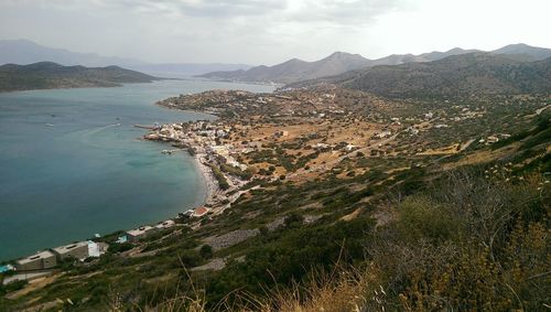 High angle view of sea and mountains against sky