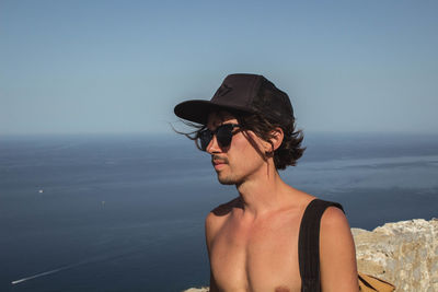 Close-up portrait of a young man in water at beach against sky