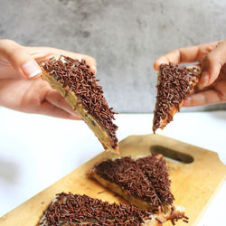 Close-up of hand holding chocolate cake