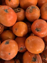 Persimmons for sale at market counter. street market.