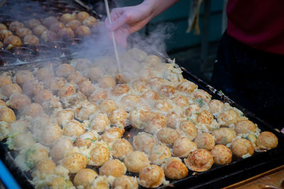 Person preparing food at market stall