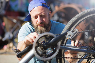 Man repairing bicycle on street in city