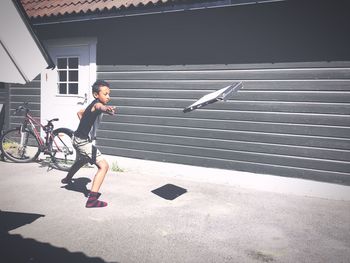 Boy throwing box on sunny day