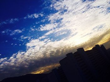 Buildings in city against cloudy sky