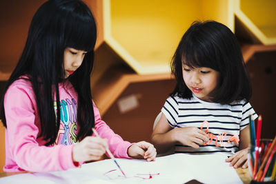 Close-up of girl holding hands on table