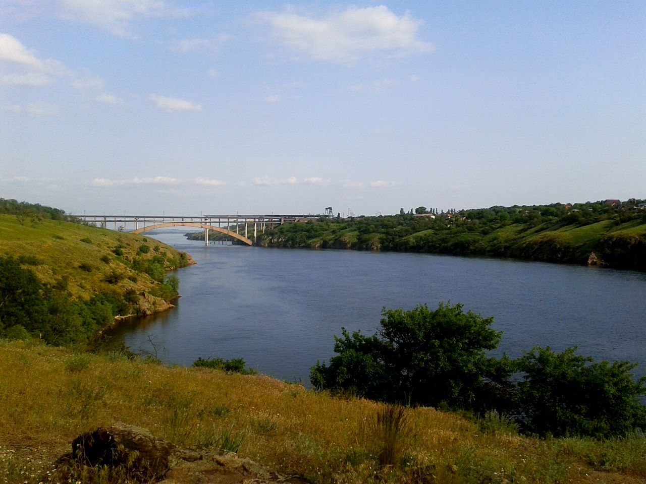 water, tranquil scene, river, tree, scenics, sky, bridge - man made structure, connection, tranquility, non-urban scene, nature, plant, beauty in nature, day, green color, growth, blue, outdoors, engineering, remote, riverbank, calm, cloud - sky, green, tourism, no people, bridge, solitude