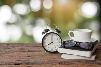 Close-up of alarm clock with personal accessories on table