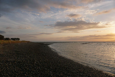 Scenic view of beach against sky during sunset