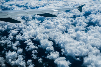 Airplane wing against cloudy sky