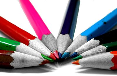 Close-up of colorful pencils over white background