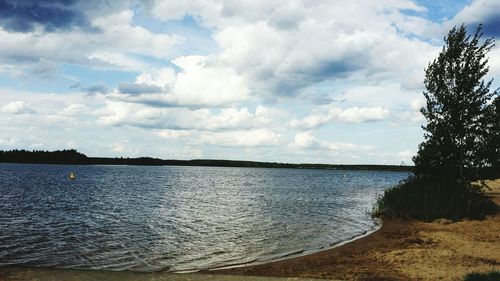 View of calm lake against cloudy sky