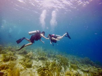 Full length of man and woman swimming in sea