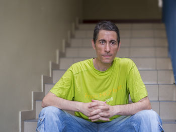 Portrait of man sitting on staircase