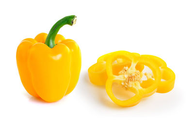 Close-up of yellow bell peppers against white background