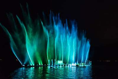 Panoramic view of illuminated sea against sky at night