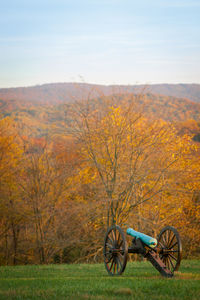 Bicycle parked on field against sky during autumn