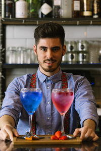 Portrait of bartender with drinks in bar