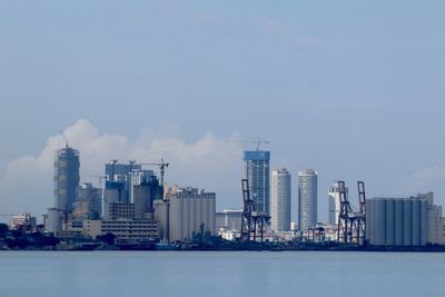 Sea by buildings against sky in colombo, sri lanka