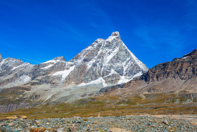 Scenic view of snowcapped mountains against clear blue sky