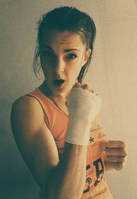 Portrait of female martial artist against wall