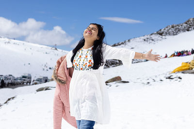 An indian beautiful woman enjoying cold in snowy mountain